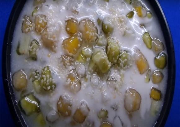 Thành phẩm chè bí đỏ khoai môn đã hoàn thành, múc ra chén và rưới thêm nước cốt dừa, sẵn sàng để thưởng thức