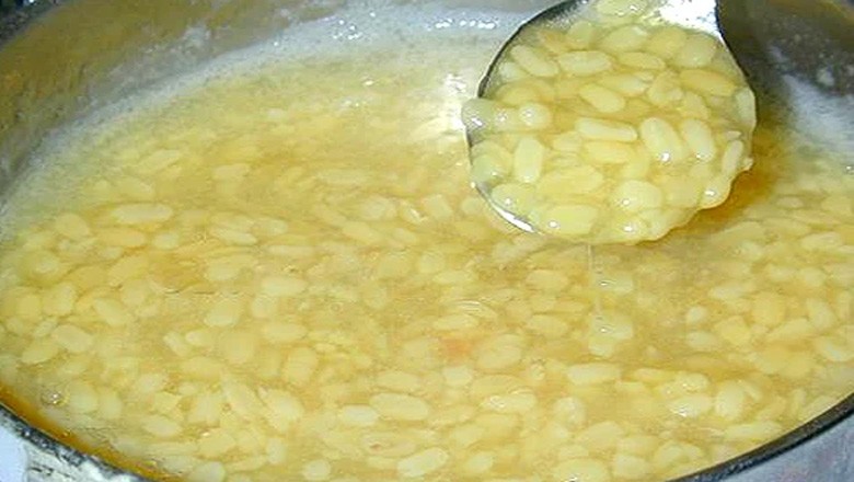Nồi chè đỗ xanh đang được khuấy đều sau khi thêm đường và bột sắn, đảm bảo độ sánh mịn cho món chè.