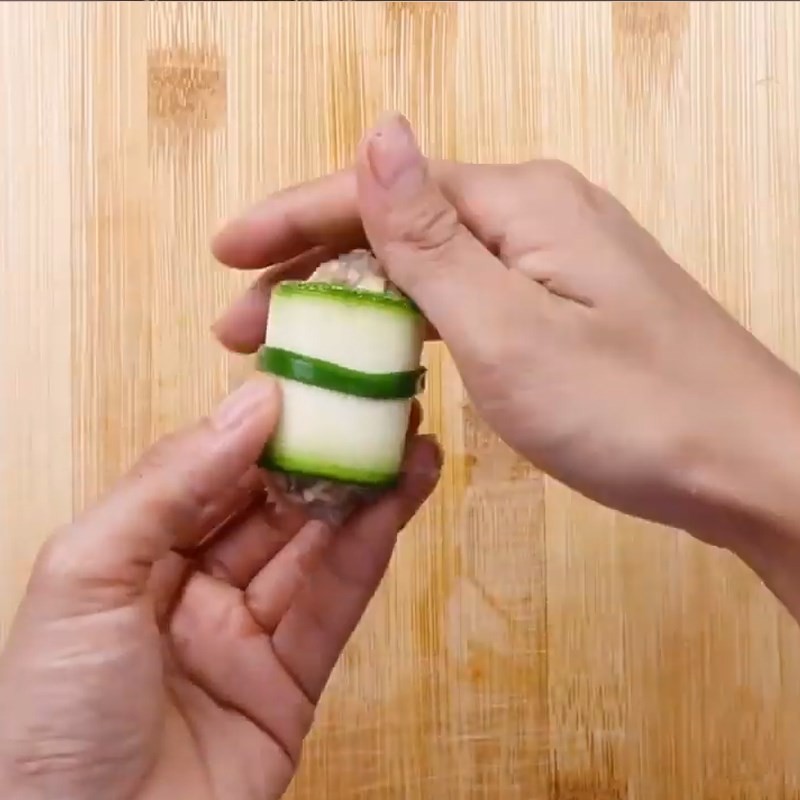 Dùng hành lá để buộc chặt cuộn bí ngòi nhân tôm, đảm bảo không bung khi nấu