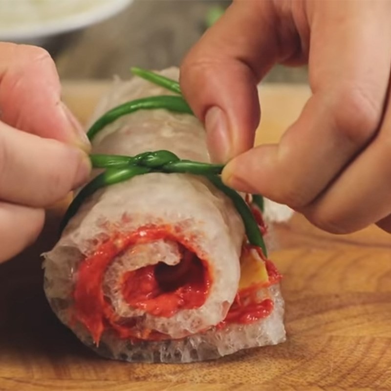 Đang thực hiện cuộn bì bóng chặt tay, đảm bảo nhân không bị bung khi hấp hoặc nấu canh