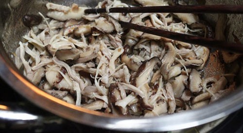 Hỗn hợp thịt gà xé và nấm đông cô đang được xào trên chảo, tạo hương vị đậm đà cho súp