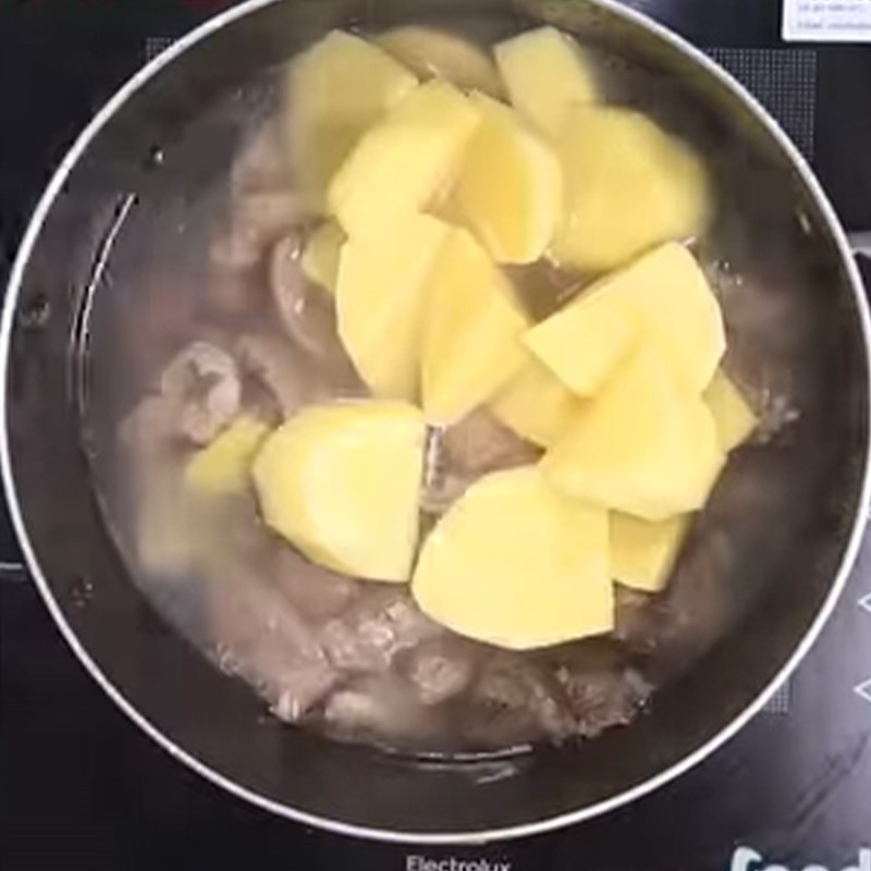 Cho khoai tây, cà rốt, su hào vào nồi gân bò đang hầm