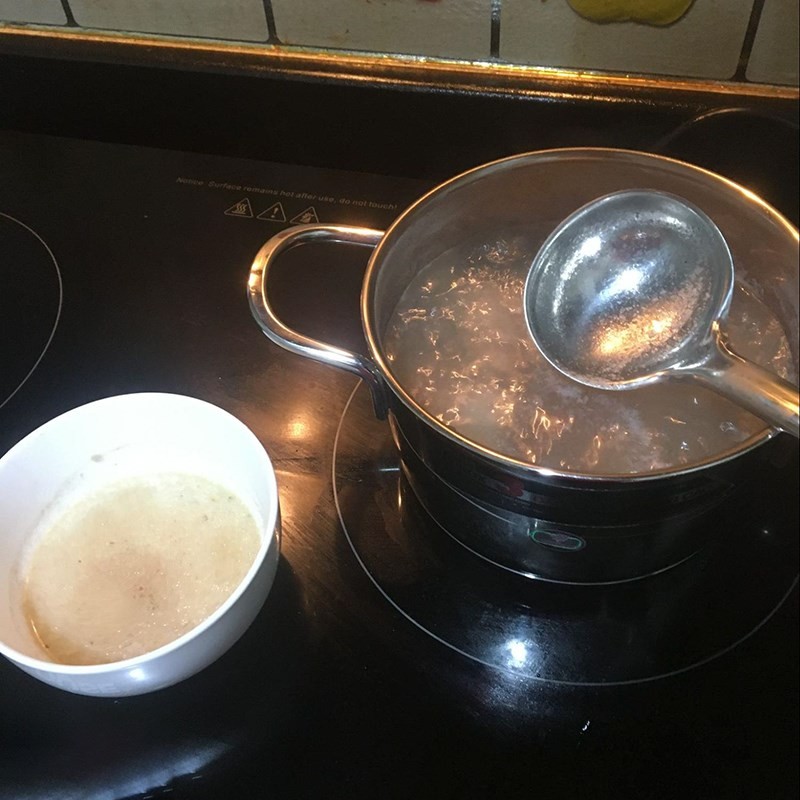 Nồi xương heo đang được hầm chậm trên bếp, giúp xương tiết ra hết chất ngọt cho nước dùng mì xương ngon