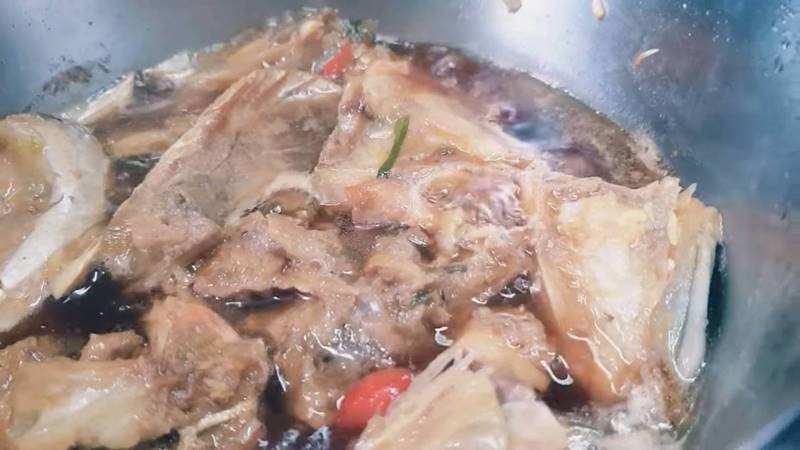 Kho cá hồi với lạc trong nồi, tạo nên hương vị đặc trưng của món cá kho lạc