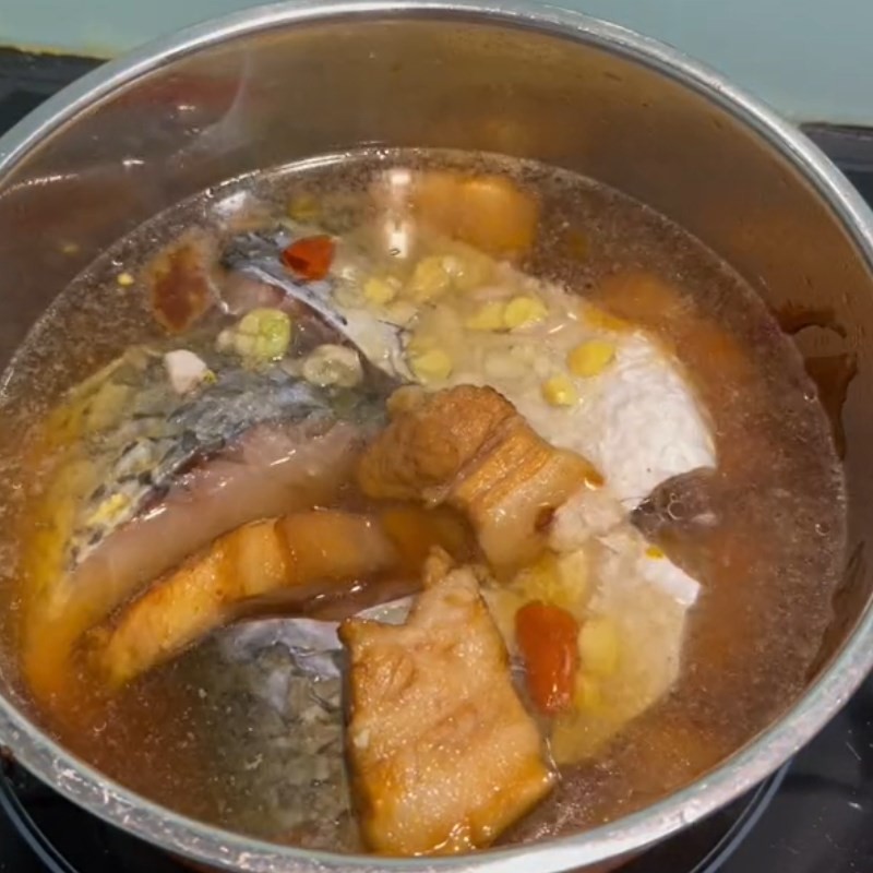 Nồi cá trắm kho thịt ba chỉ đang sôi nhẹ, đảm bảo thịt mềm rục