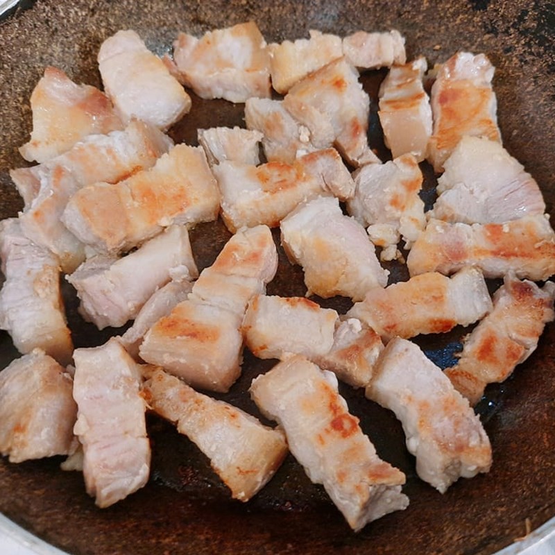 Nêm nếm gia vị vào thịt ba chỉ đang rang cháy cạnh