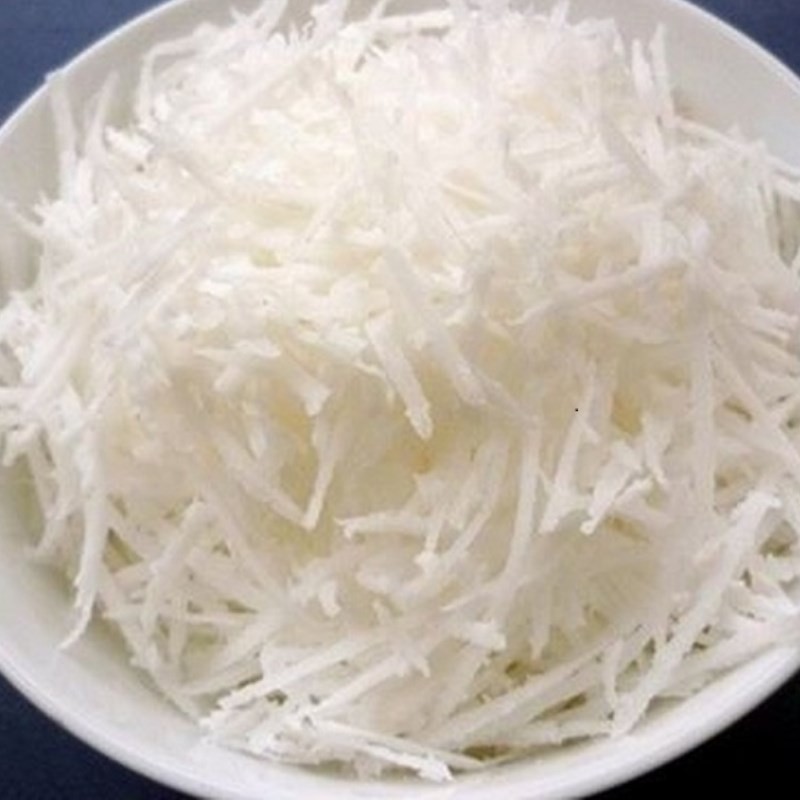 Sợi dừa nạo đang được sên với đường, tạo hương vị ngọt béo cho món xôi hạt sen