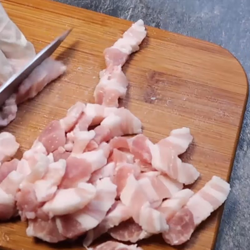 Tóp mỡ vàng giòn rụm đang được trộn đều với hành lá và đường, làm tăng hương vị cho món cơm hấp