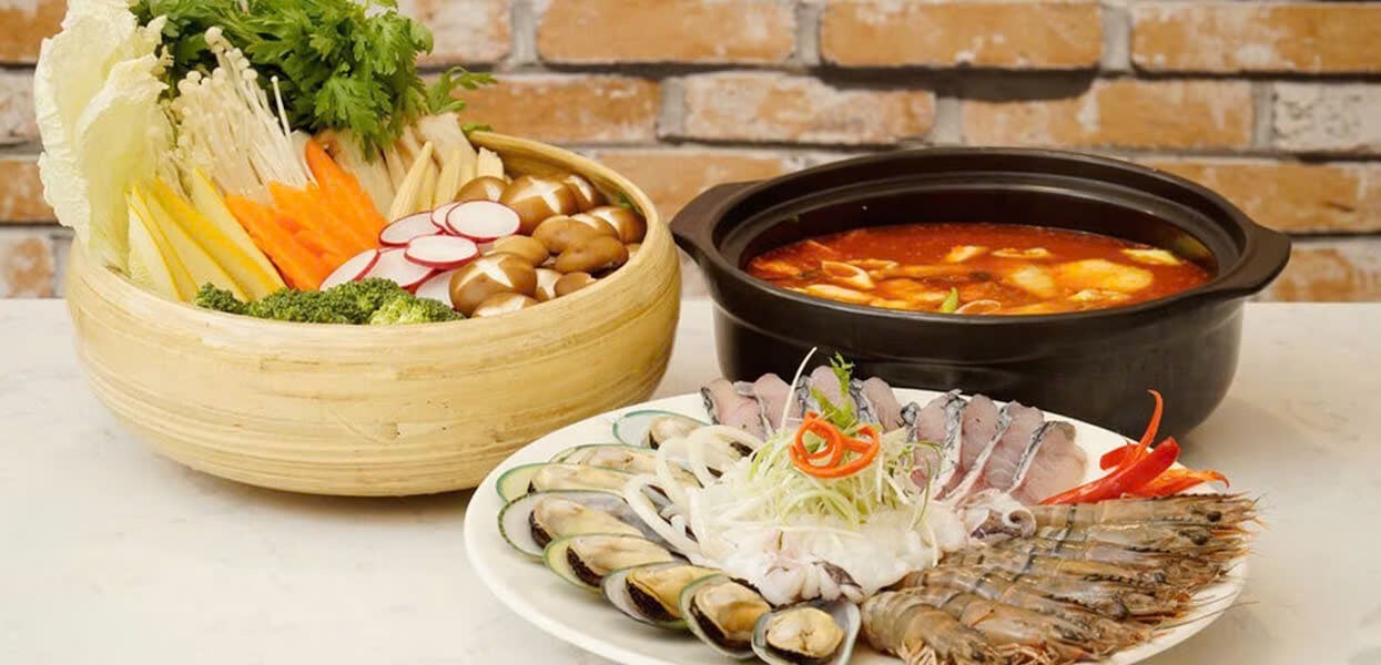 Bàn ăn thịnh soạn với lẩu kim chi Hàn Quốc nóng hổi, sẵn sàng thưởng thức