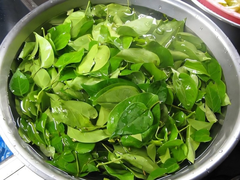 Sơ chế các nguyên liệu rau thơm và cà chua để chuẩn bị cho món lẩu cá kèo rau đắng