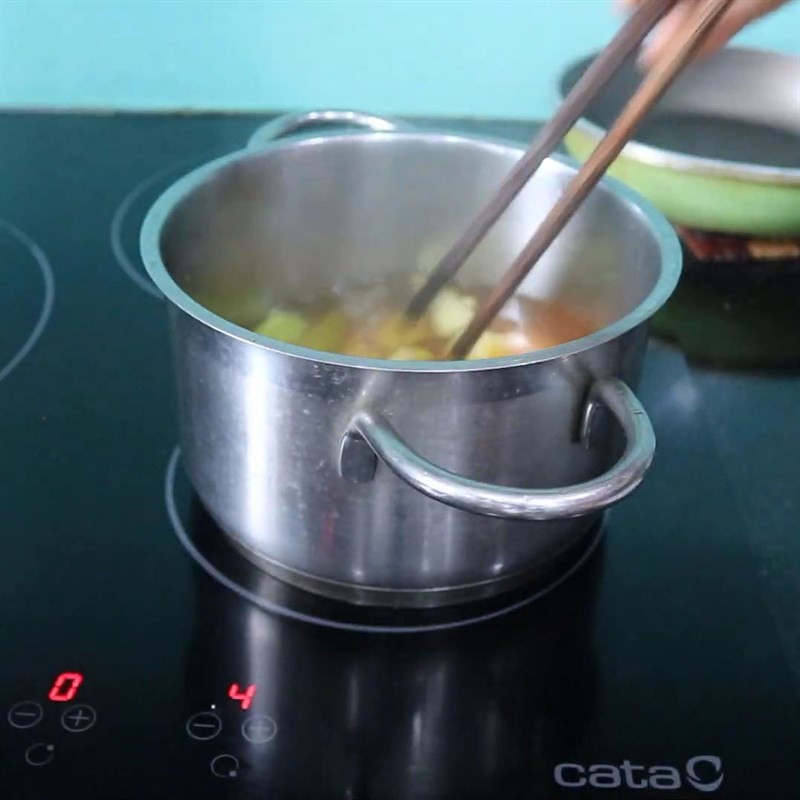 Luộc chuối xanh với bột nghệ để giảm chát và tạo màu đẹp