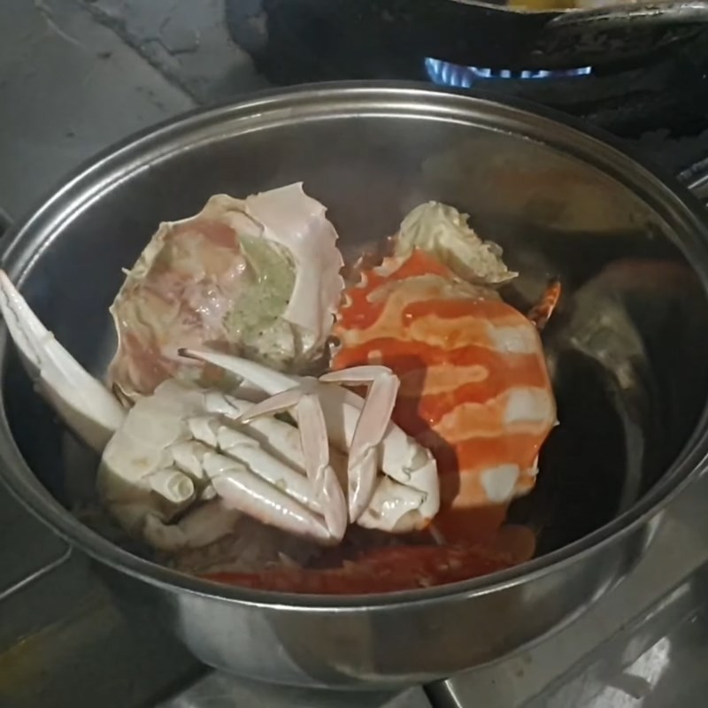 Ghẹ đang được luộc chín trong nồi nước lẩu ghẹ rau muống, vỏ chuyển màu cam đẹp mắt