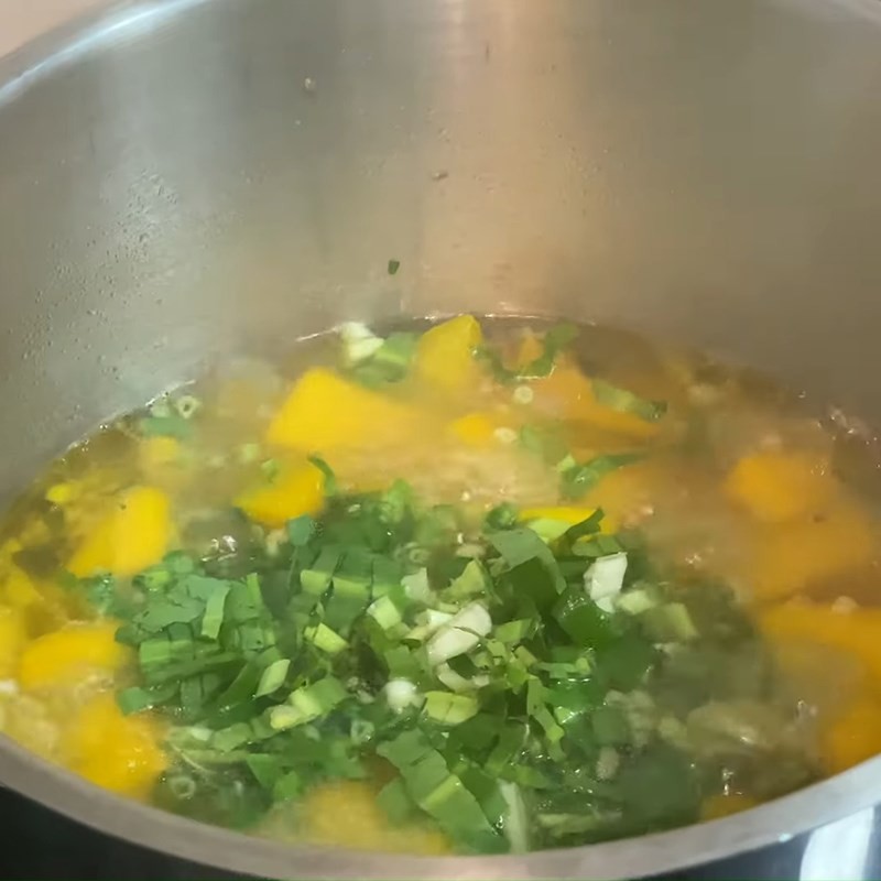Hoàn thiện món canh bí đỏ chay bằng cách thêm rau thơm và nêm nếm lại