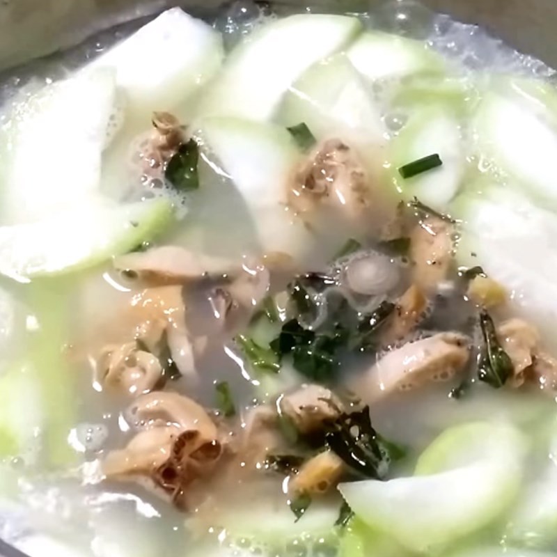 Nồi canh trai nấu bầu đang sôi, bầu chín mềm, thịt trai đậm đà