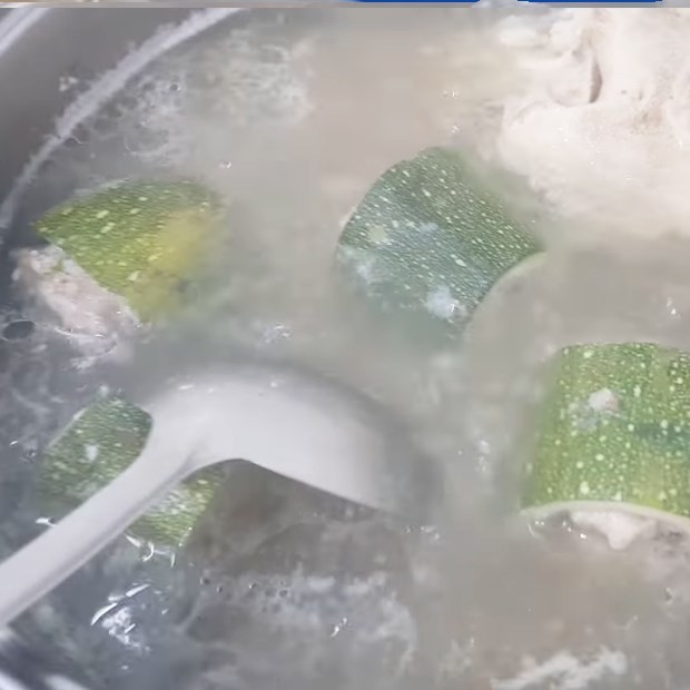 Cho các khoanh bí ngòi nhồi thịt vào nồi nước xương đang sôi để nấu chín