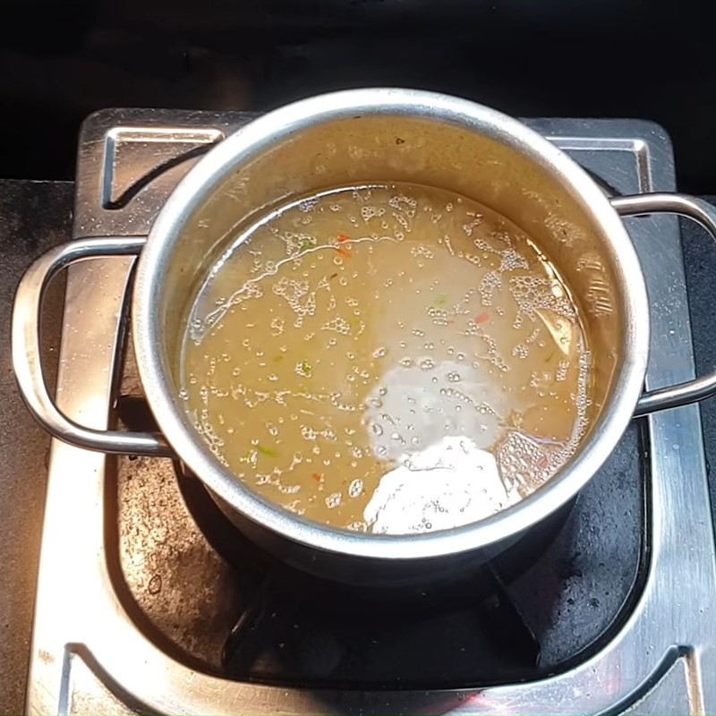 Thêm nước vào nồi mì căn đang xào