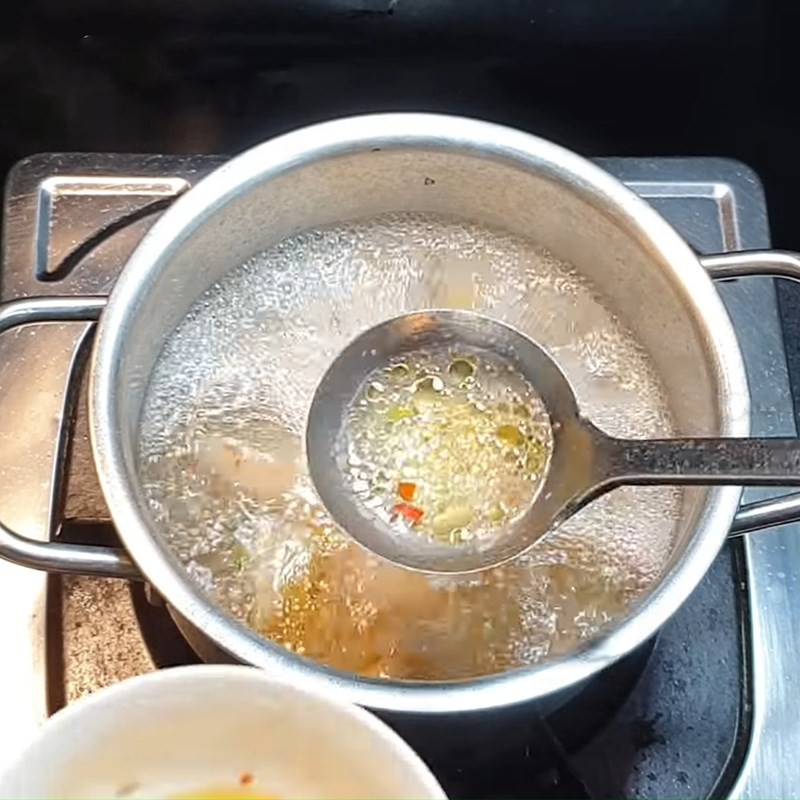 Hớt bọt và váng dầu trên mặt nước canh khi sôi