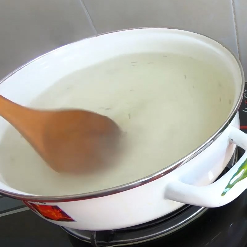 Nước dùng canh hẹ đậu hũ đang sôi nhẹ trên bếp, sẵn sàng cho các nguyên liệu tiếp theo
