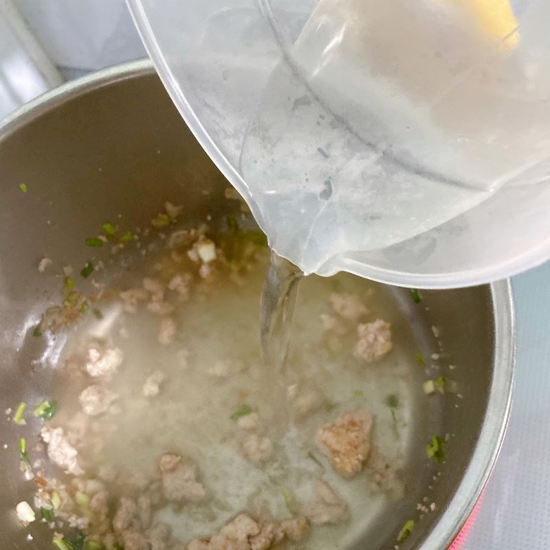 Hình ảnh thịt băm đang được xào trong nồi, chuẩn bị cho món canh cà chua thịt băm