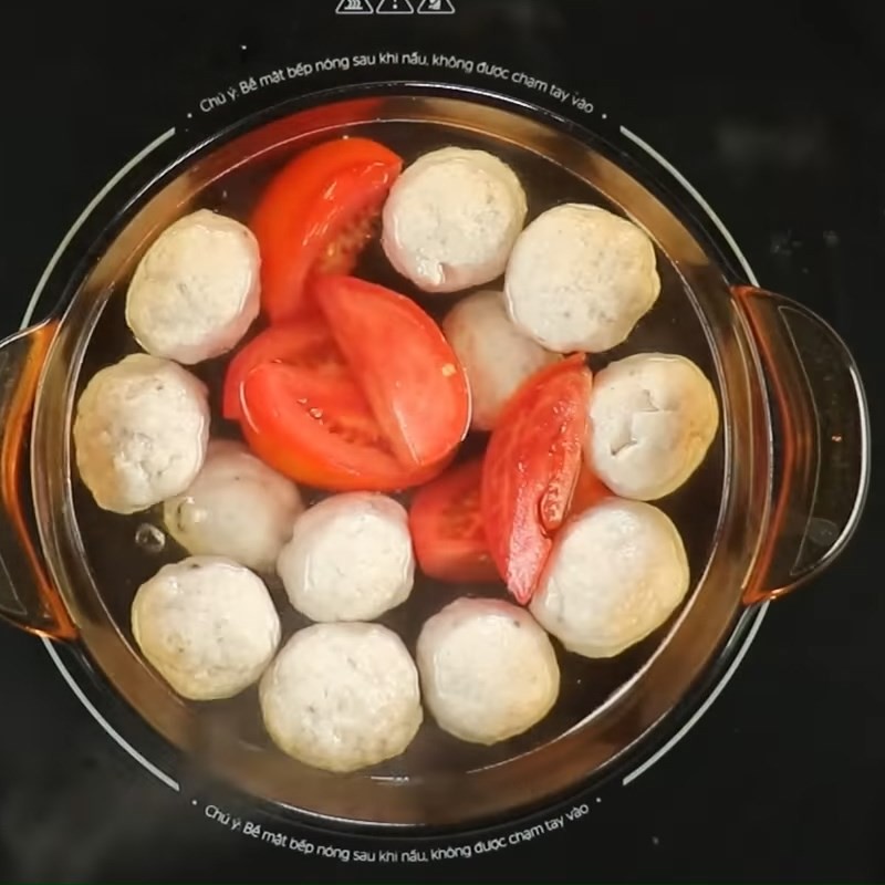 Thêm cà chua, hành tây, đầu hành lá và cần tàu vào nồi canh cá thác lác