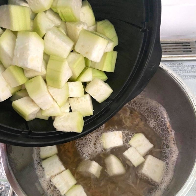 Thêm bầu vào nồi tép khô đang sôi, chuẩn bị hoàn thành món canh bầu với tép