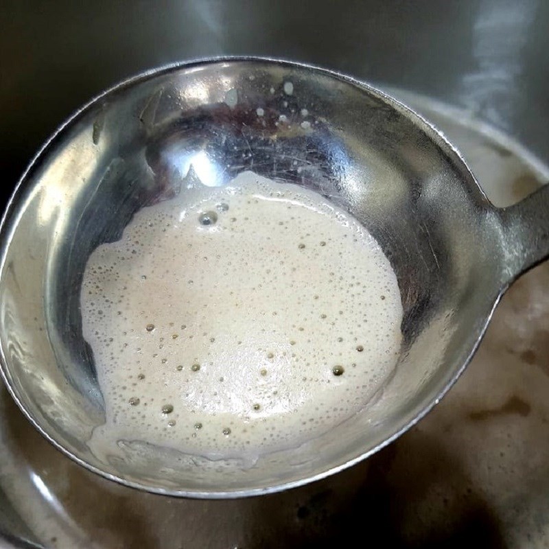 Đổ nước dùng xương cá rô vào nồi nấu canh rau cải