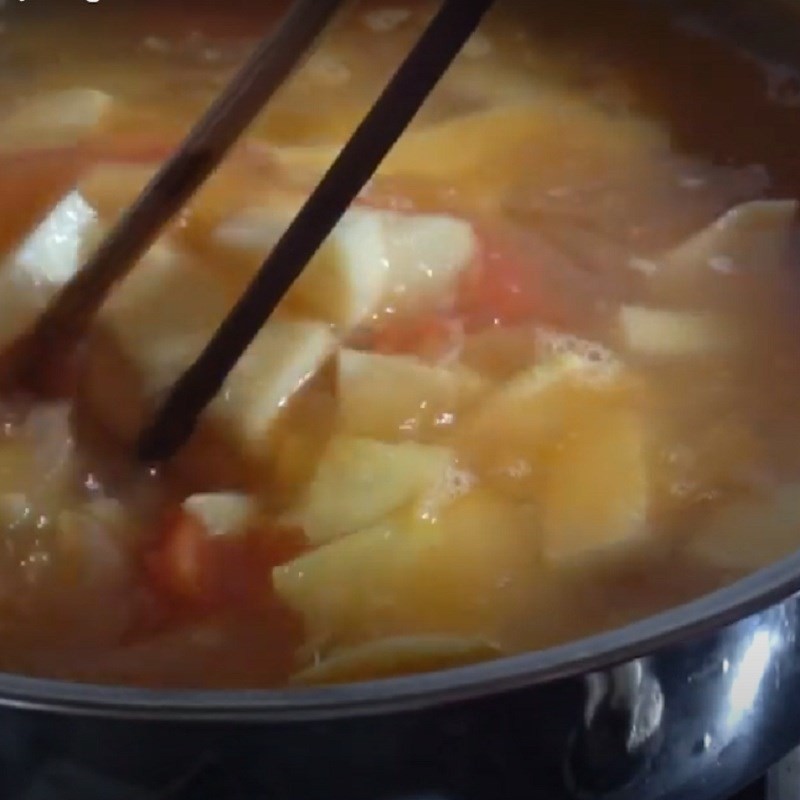 Thêm cà chua vào nồi canh chua cá tầm