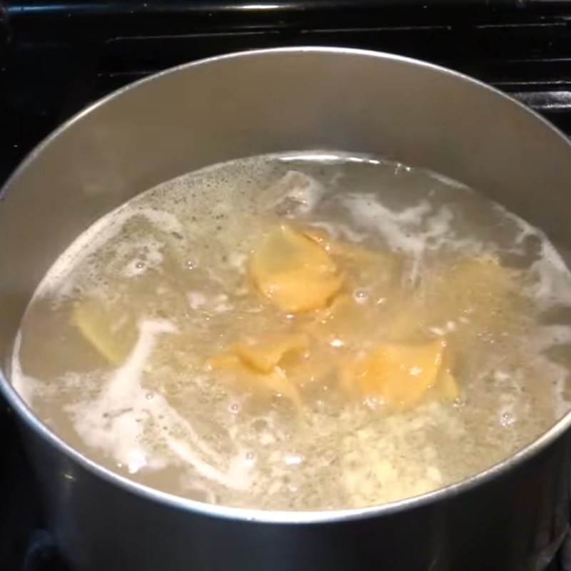 Cho củ cải muối đã sơ chế vào nồi canh đang hầm, để củ cải thấm vị và làm tăng hương vị độc đáo của canh củ cải muối