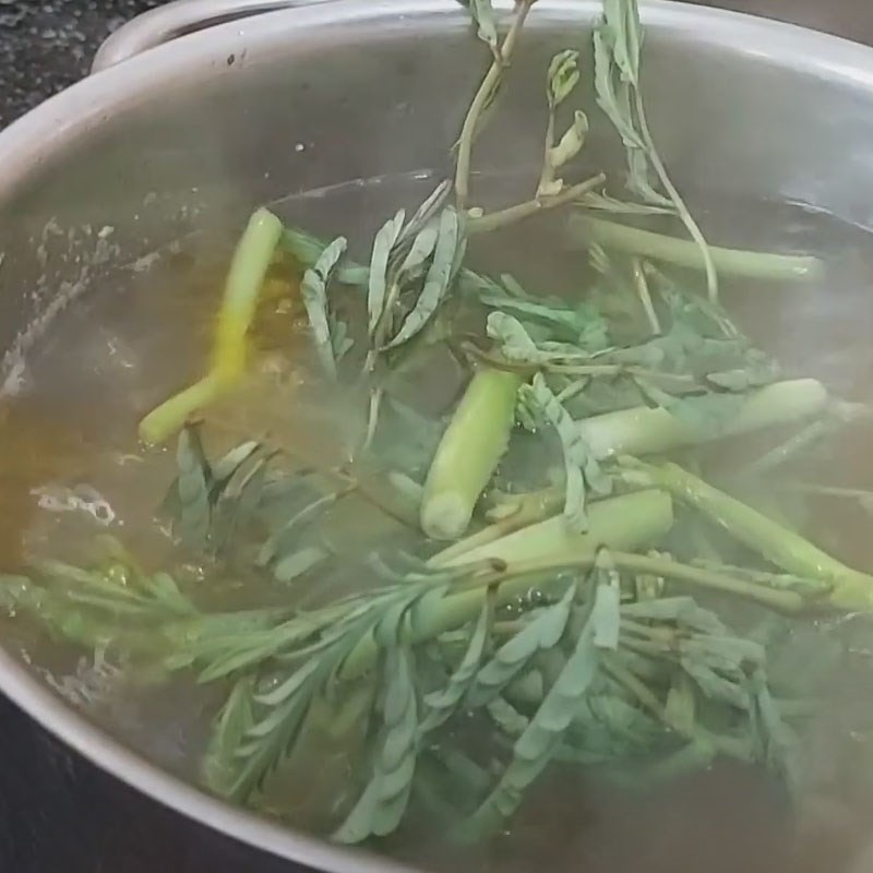 Mô tả nồi canh cua rau muống đang được đun trên bếp, rau muống và riêu cua nổi hấp dẫn