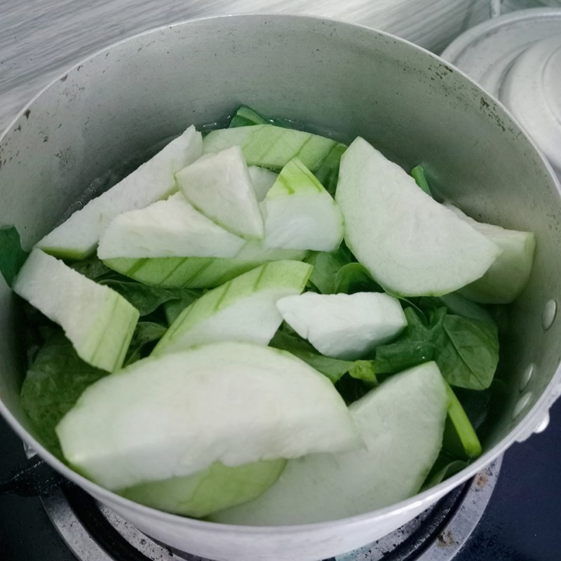 Thêm rau mồng tơi vào nồi canh đang sôi, giữ độ tươi xanh cho món ăn