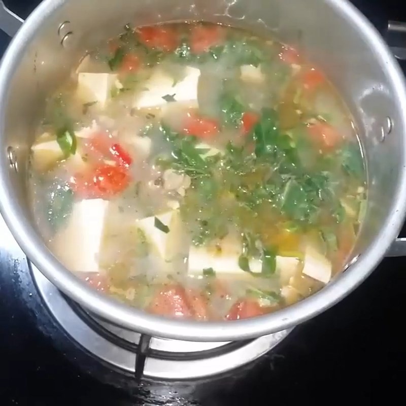 Thêm hành lá, rau răm và lá lốt vào nồi canh ngao đậu phụ để hoàn thiện hương vị