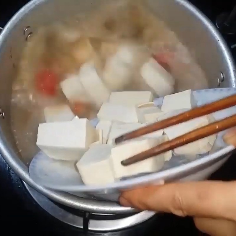 Đổ nước luộc ngao vào nồi, bắt đầu quá trình nấu canh ngao đậu phụ thanh mát