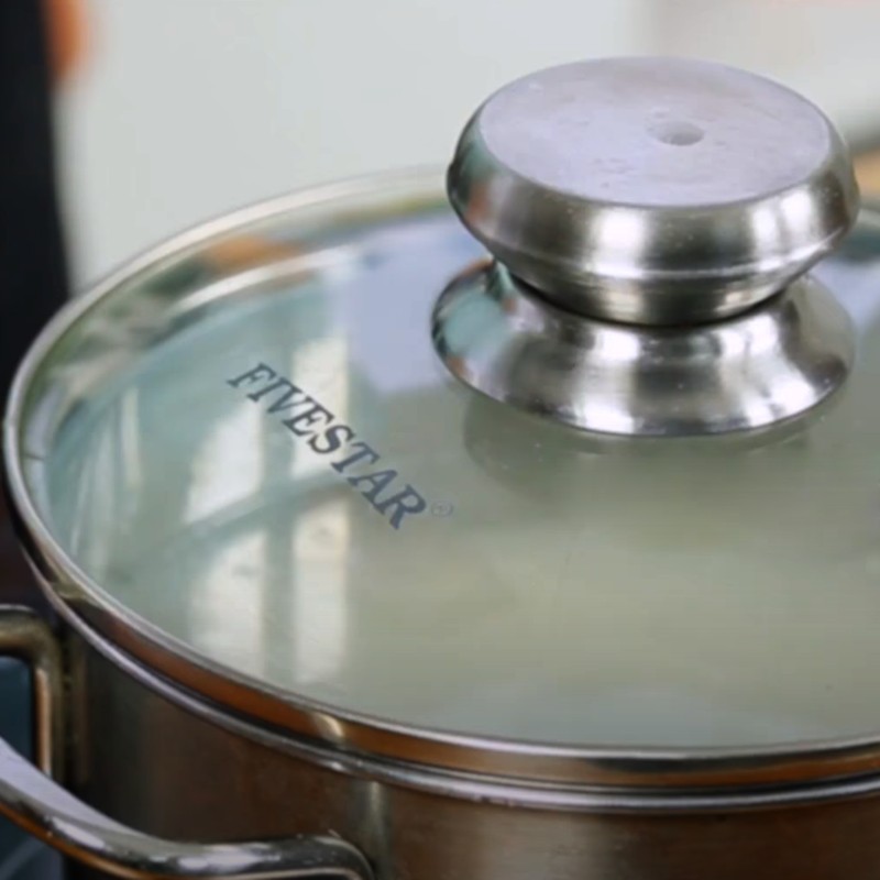 Cháo được nấu trong nồi trên bếp, hạt gạo đã nở bung ra.