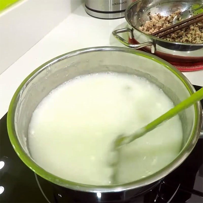Đổ nước và cho yến mạch vào nồi thịt gà đang sôi để bắt đầu nấu cháo gà yến mạch