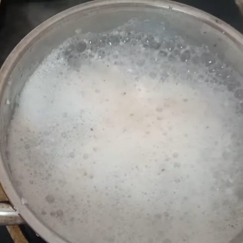 Cháo gạo vỡ đang sôi nhẹ, chuẩn bị ủ mềm