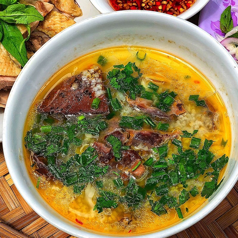 Tô cháo vịt nóng hổi, nghi ngút khói, với hành ngò và tiêu xay, sẵn sàng thưởng thức