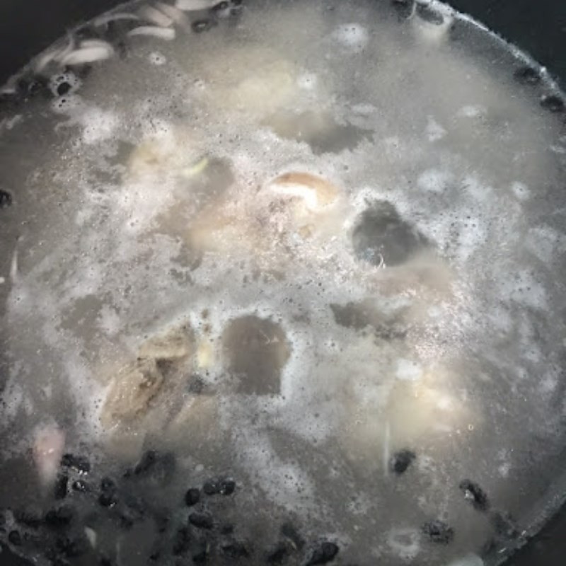 Nồi cháo giò heo đậu đen đang sôi nhẹ, đảm bảo cháo chín đều và sánh mịn.