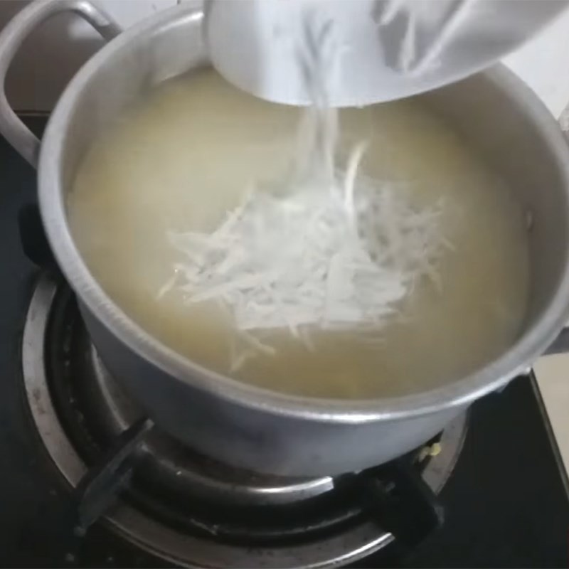 Rắc dừa bào sợi vào nồi chè cốt dừa đậu xanh, tăng thêm hương vị và độ giòn nhẹ