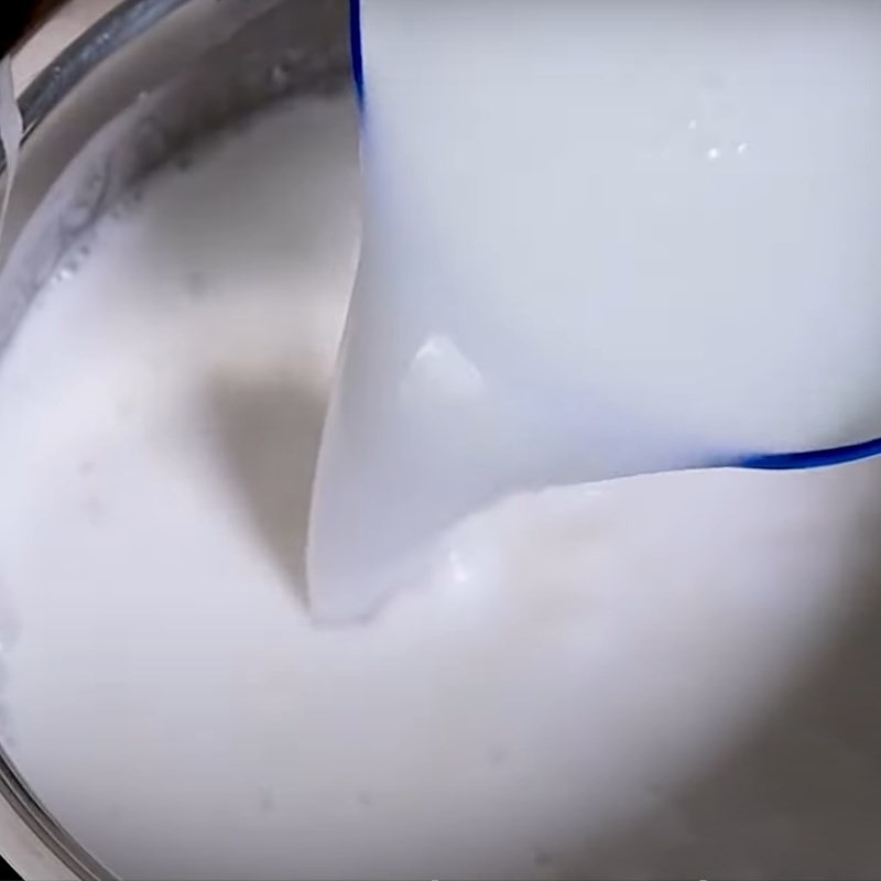 Nước cốt dừa đang được nấu trên bếp với bột năng để tạo độ sánh