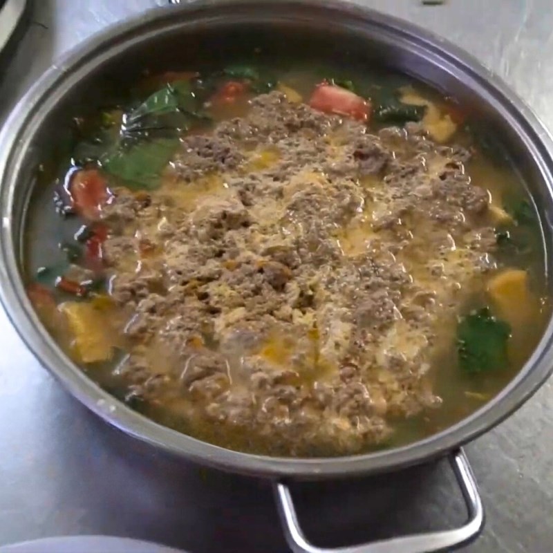 Rắc hành lá lên trên nồi lẩu cua da nóng hổi