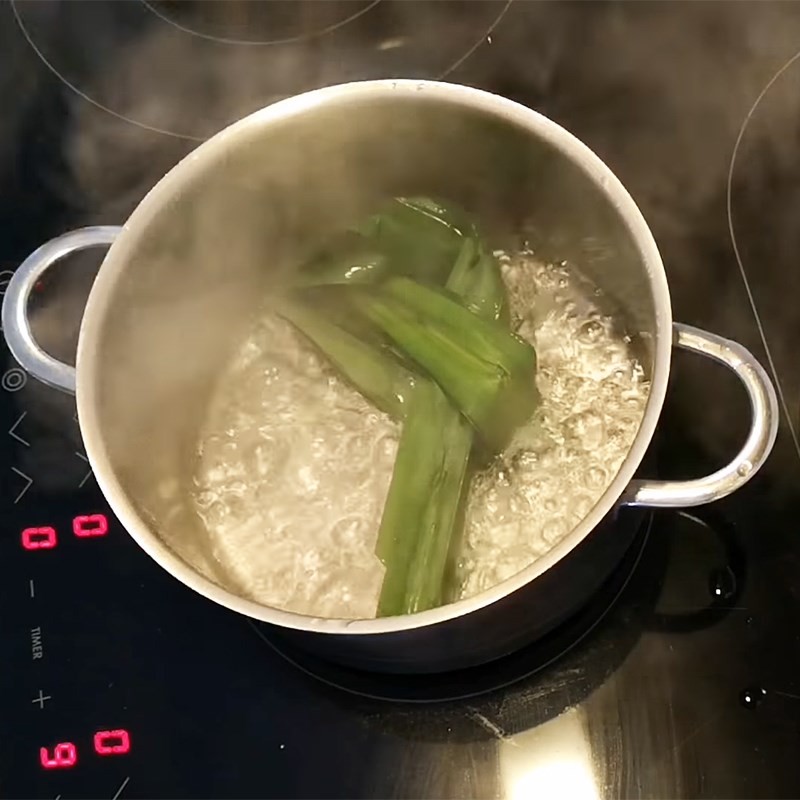Nồi nước đường phèn đang sôi với lá dứa, tạo hương thơm cho cách nấu chè chuối khoai môn