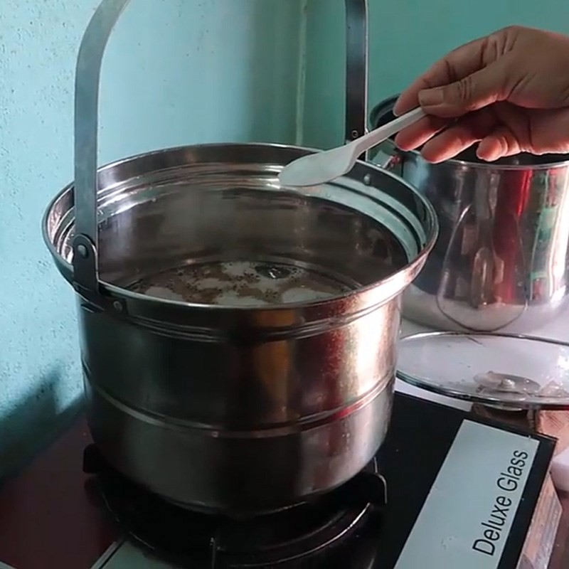 Nêm nếm gia vị vào nồi cháo gân bò, thêm hành lá và ngò gai
