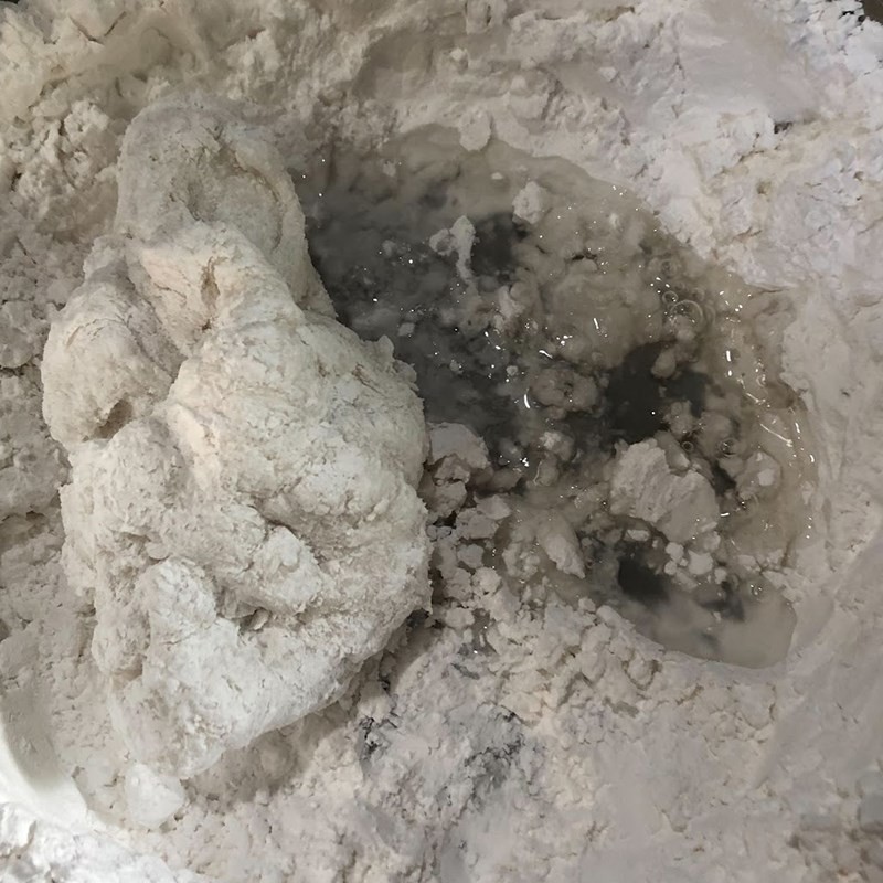 Khuấy đều bột năng với nước sôi bằng đũa để tạo thành khối bột ban đầu