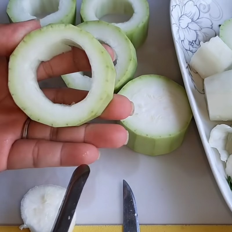 Nhồi chặt nhân chay vào từng khoanh bầu đã chuẩn bị