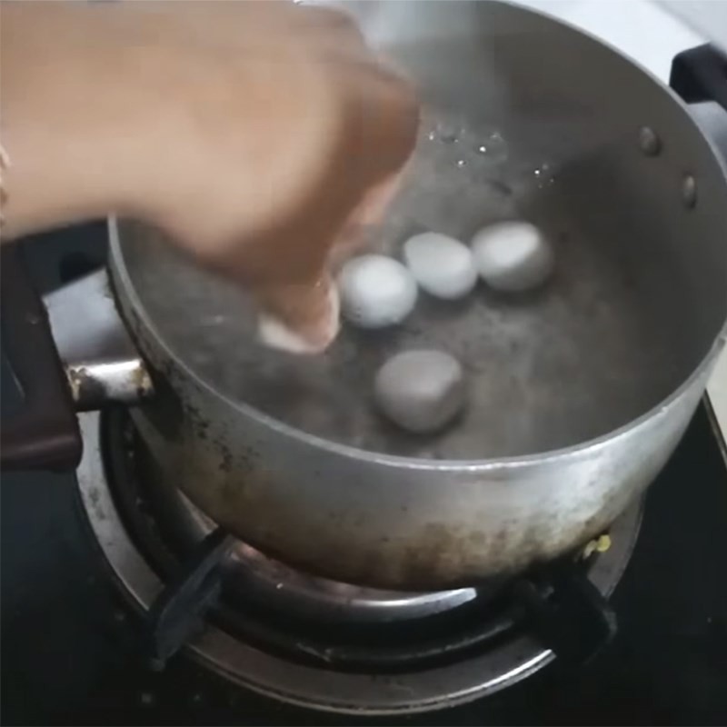 Bánh trôi nước nhân đậu xanh đang được thả vào nồi nước sôi để luộc chín
