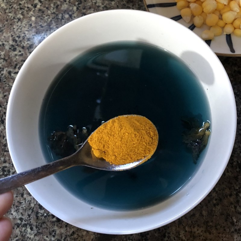 Pha tinh bột nghệ với nước hoa đậu biếc để tạo màu xanh lá cho xôi