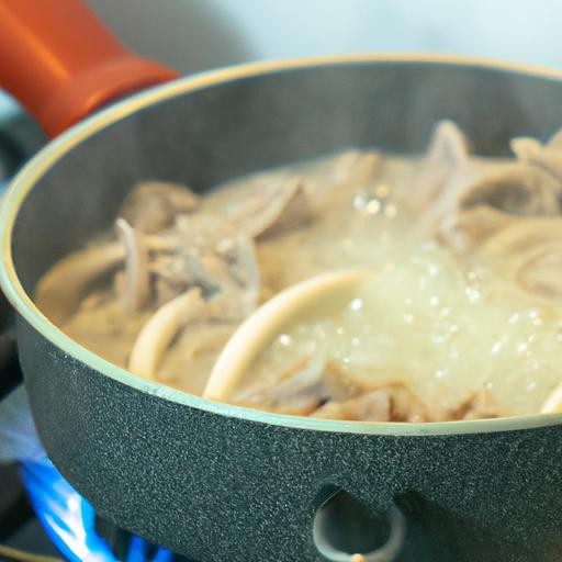 Quá trình chế biến miến thịt heo: Nồi nước dùng hoặc các nguyên liệu đang được ninh trên bếp ga, chuẩn bị cho món miến thơm ngon.