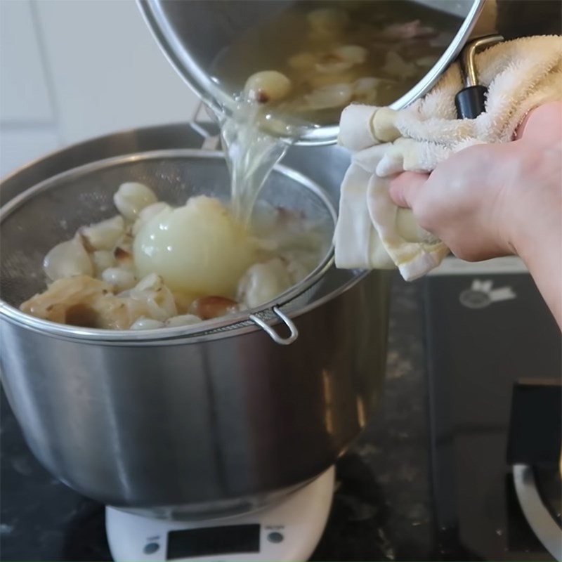 Lọc nước dùng phở qua rây để loại bỏ bã hành, gừng, giúp nước dùng trong và mịn