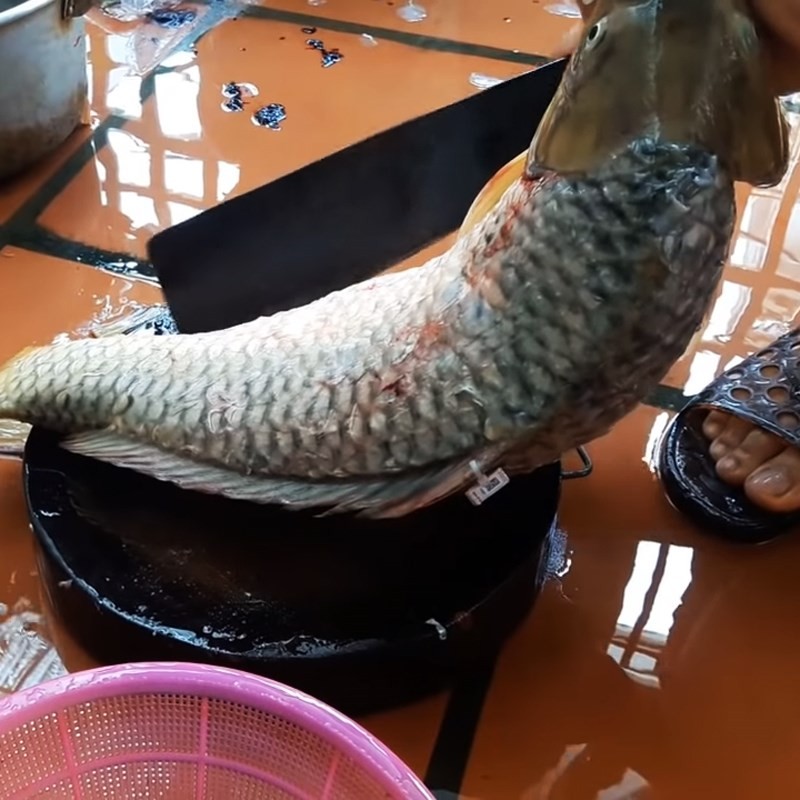 Rửa cá chép dưới vòi nước chảy mạnh để loại bỏ tạp chất