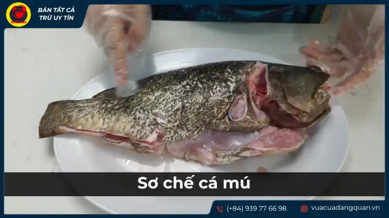 Người đang sơ chế cá mú cẩn thận, loại bỏ xương để chuẩn bị nấu cháo cá mú cho bé an toàn.